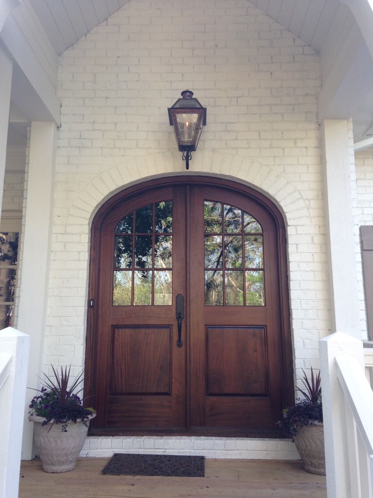 Brown Arched Glass Front Door On White Brick Home (View 11 of 32)