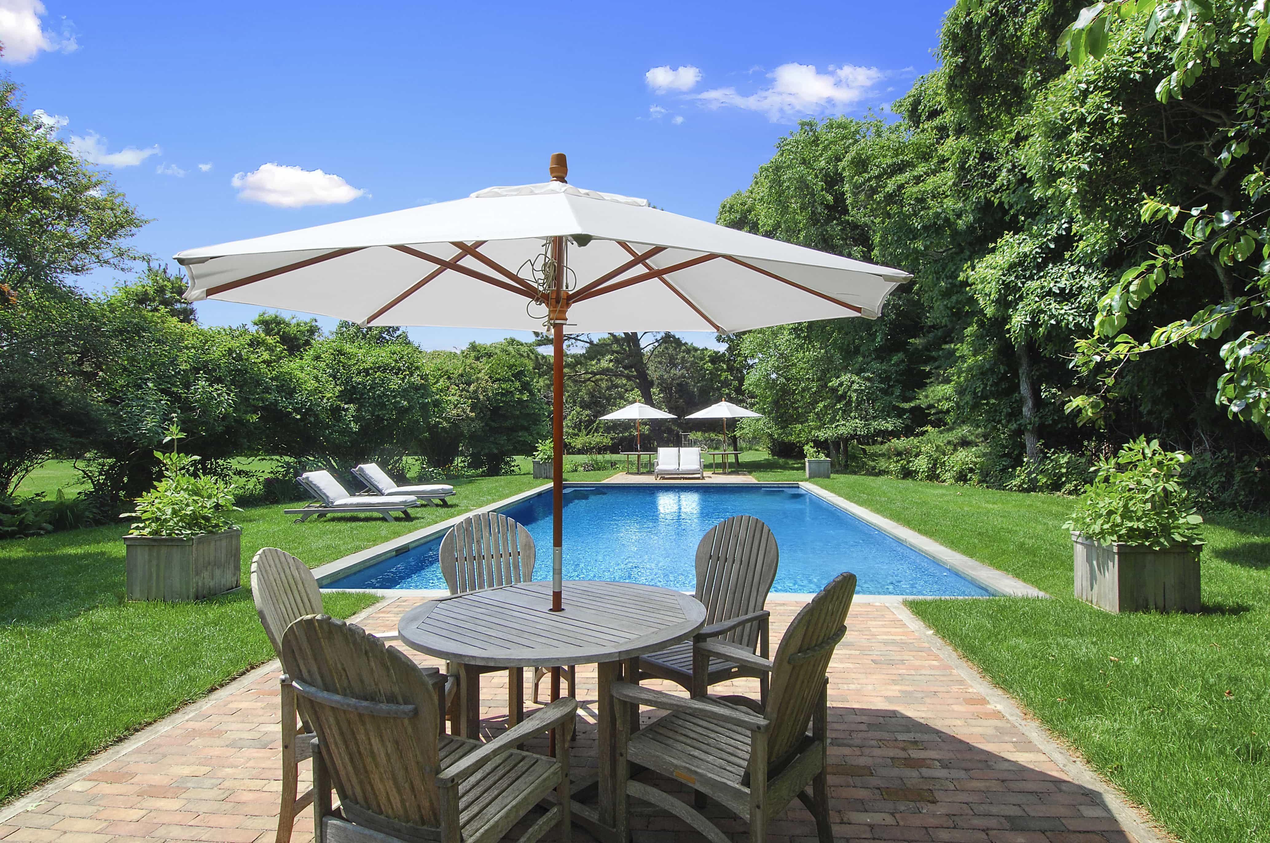 Sunny New York Swimming Pool With Brick Patio And Wooden Outdoor Furniture (Photo 3 of 25)