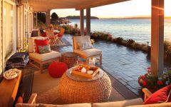 Covered Waterfront Patio With Stone Floor and Woven Ottoman